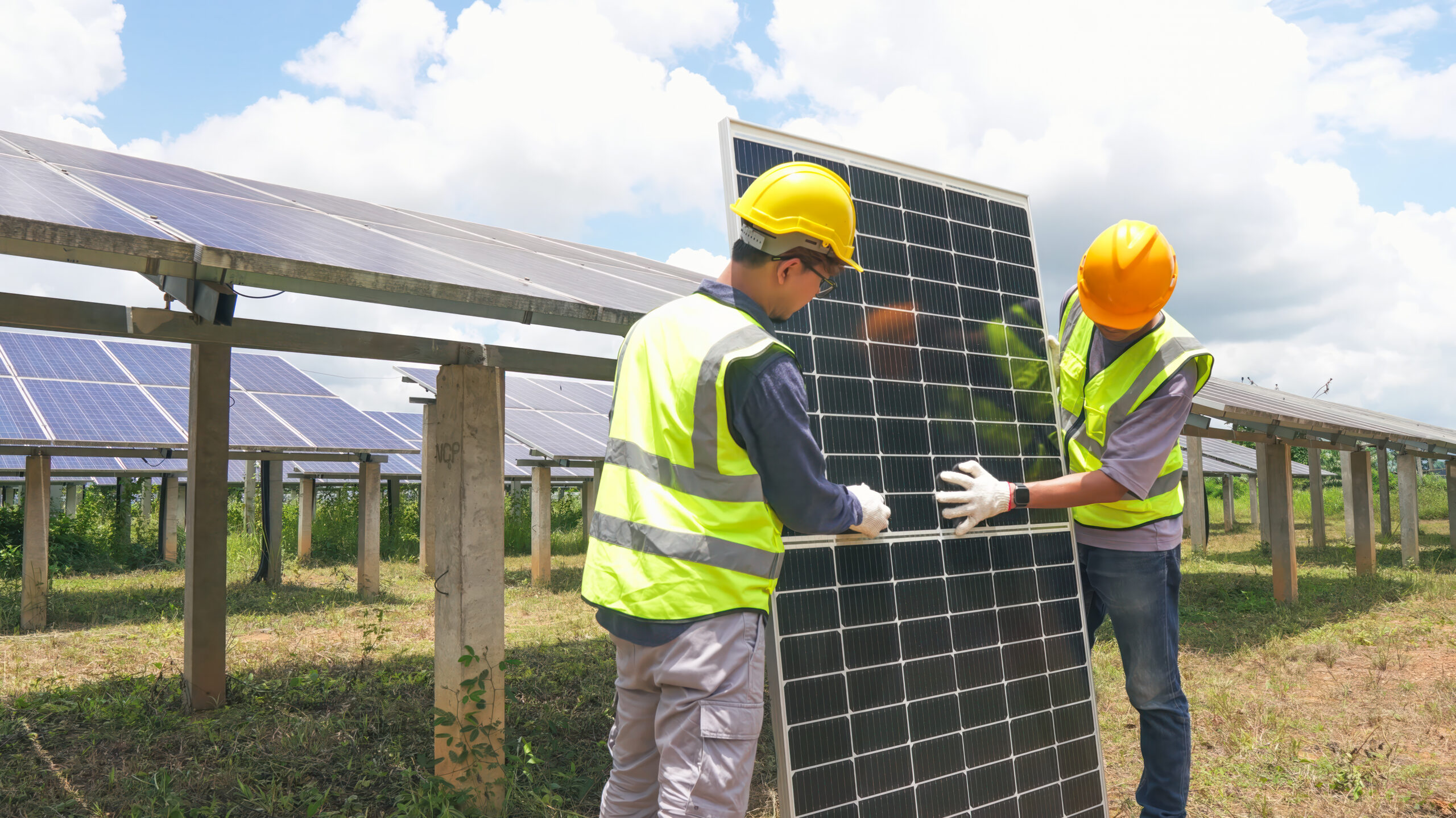 two asian engineers installing solar panels . solar energy clean